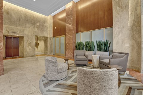 a lobby of a hotel with chairs and a table