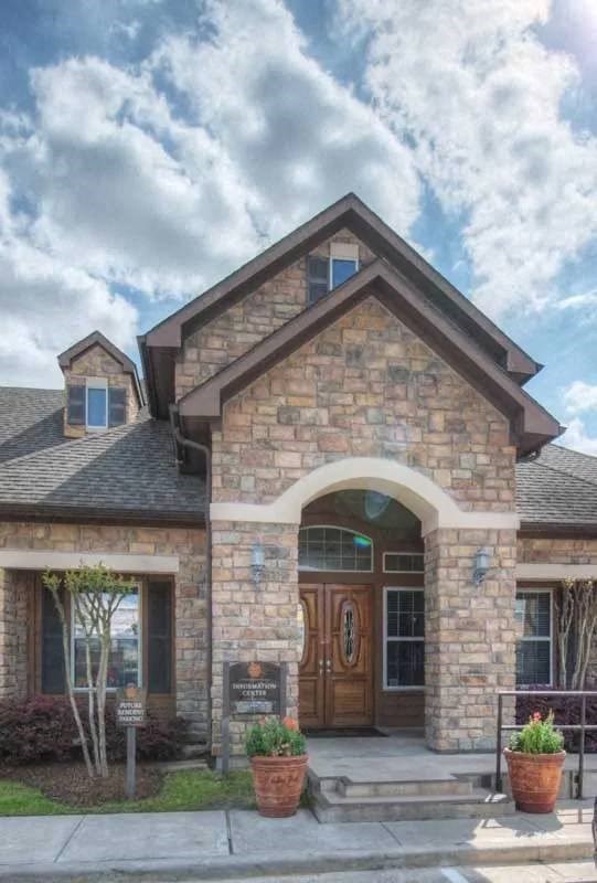 A stone building with a brown door and windows.