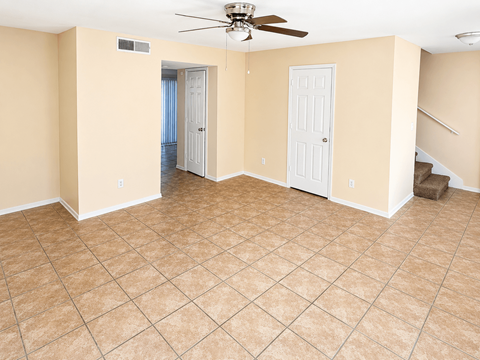 A room with a ceiling fan and tile flooring.