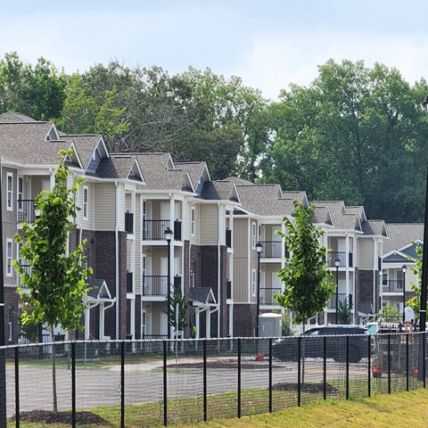 A row of townhouses with trees in front.