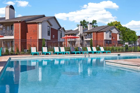 A swimming pool in front of a row of houses.