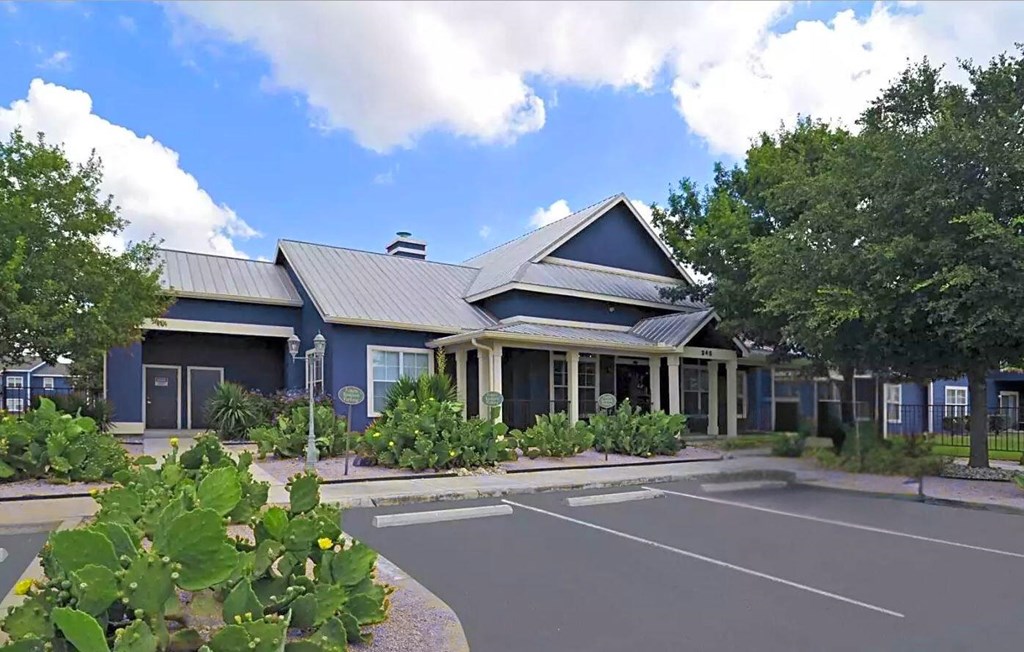 A blue building with a parking lot in front.