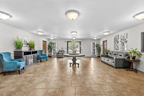 A spacious living room with a variety of furniture and plants.