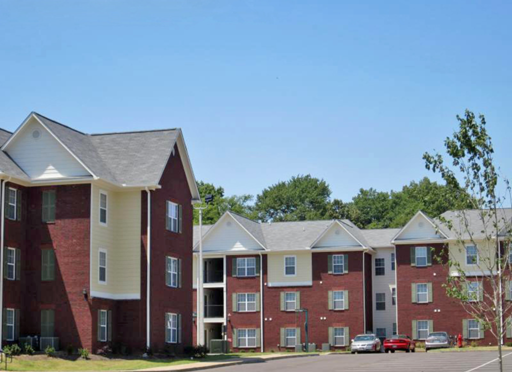 an apartment building with cars parked in front of it