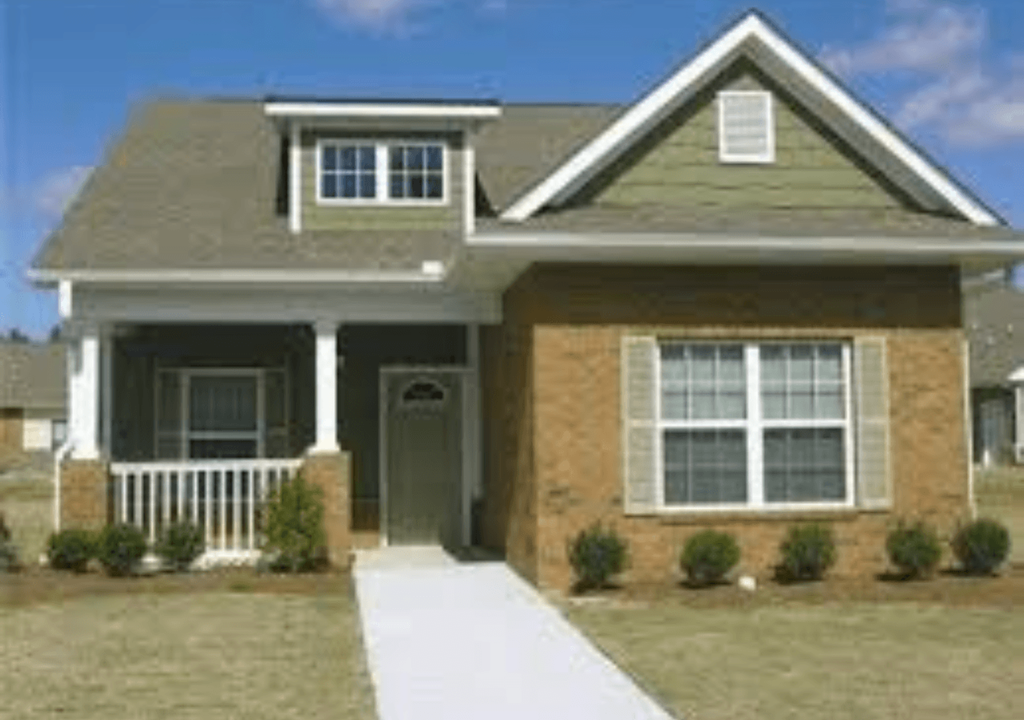a brown house with a white sidewalk in front of it