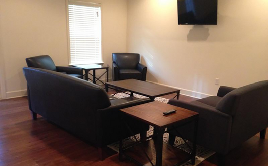 a living room with couches and tables and a tv