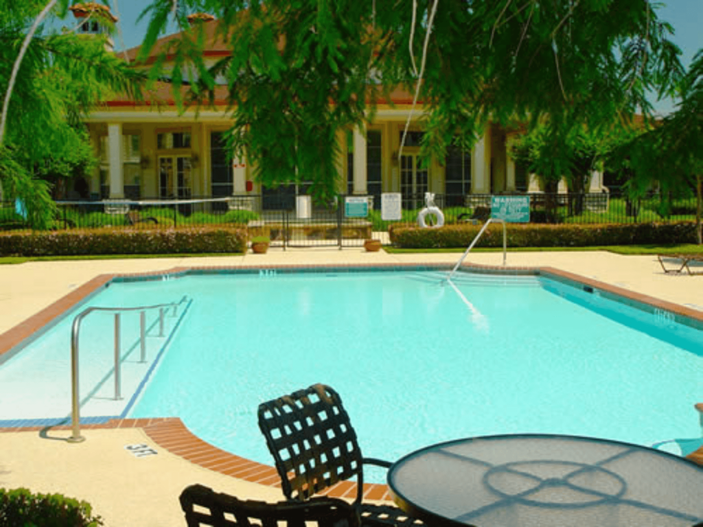a swimming pool with a table and chairs around it