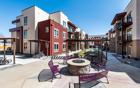 an outdoor patio with tables and chairs and a fire pit