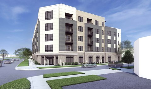 A modern apartment building with a parking lot in front.