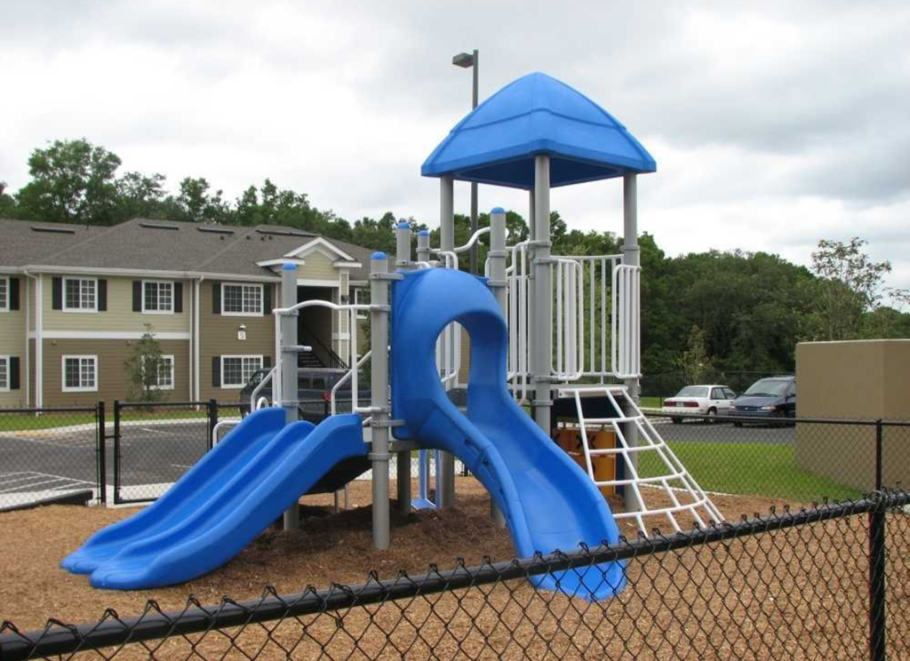 a playground with a blue slide and a white tower