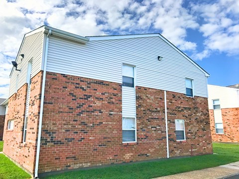 the side of a brick building with white siding