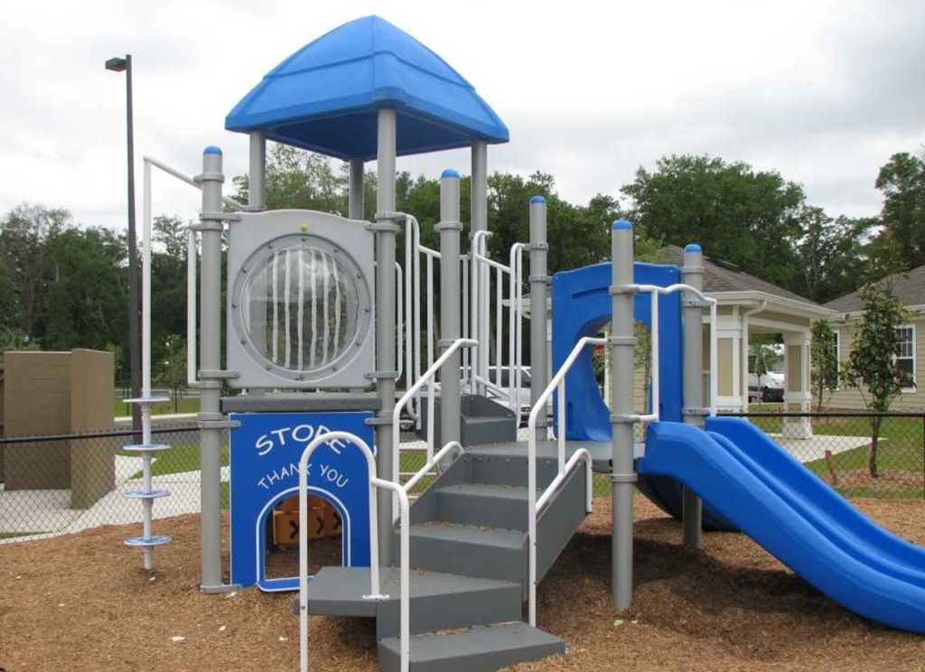 a playground with a blue and gray playset and stairs