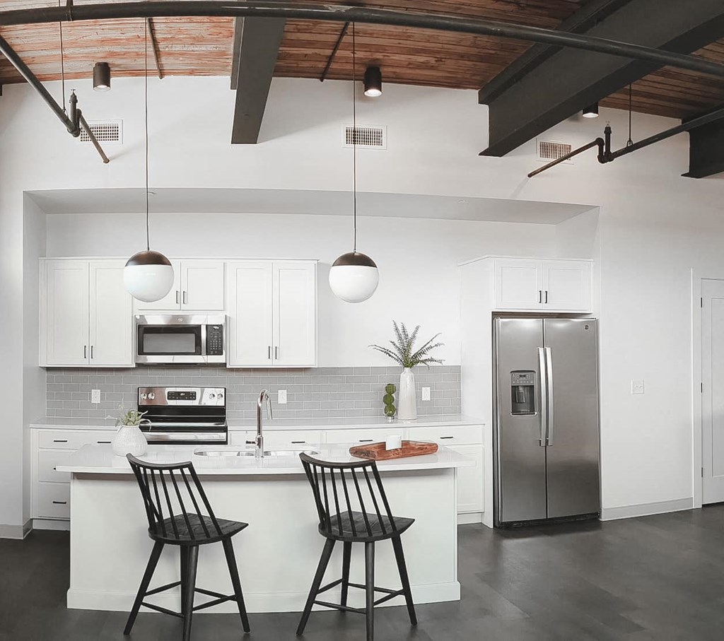 a kitchen with white cabinets and stainless steel appliances at The Mill at Prattville, Alabama