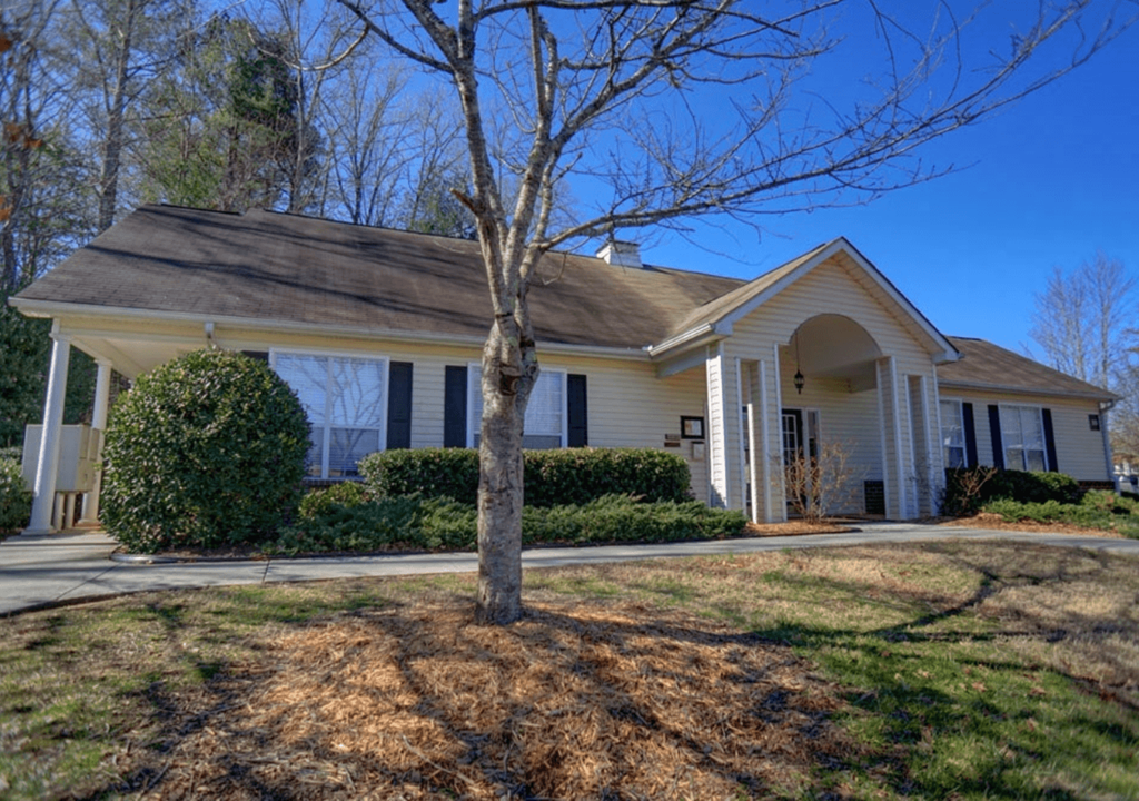 a white house with a tree in front of it
