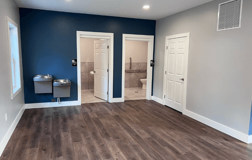 a empty room with two doors and a bathroom