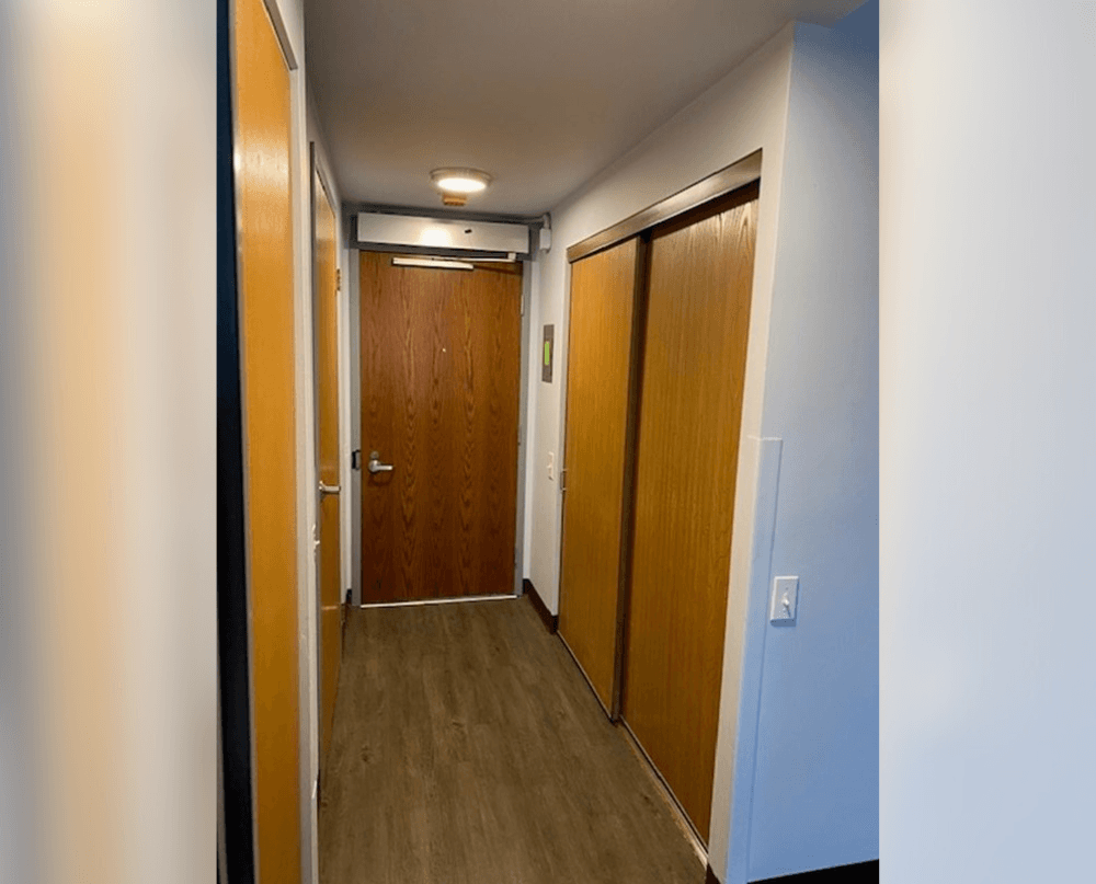 a hallway with two doors and a door to a bathroom