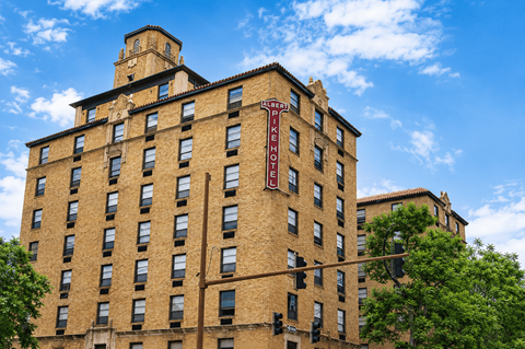 A tall brick building with a clock tower on the top.