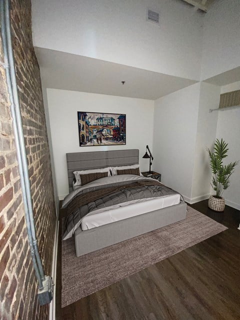 a bedroom with a bed and a brick wall at Lofts at Union Alley, Tennessee