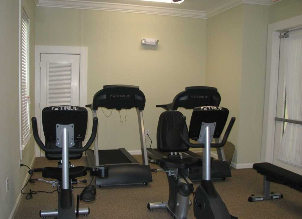 a home gym with a row of exercise machines