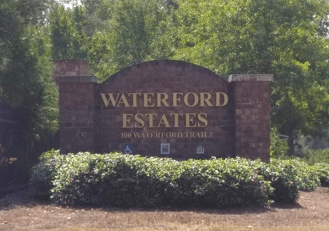 a sign for waterford estates in front of trees