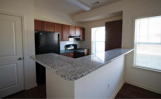 an empty kitchen with a granite counter top