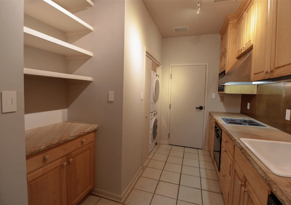 A kitchen with wooden cabinets and a white sink.