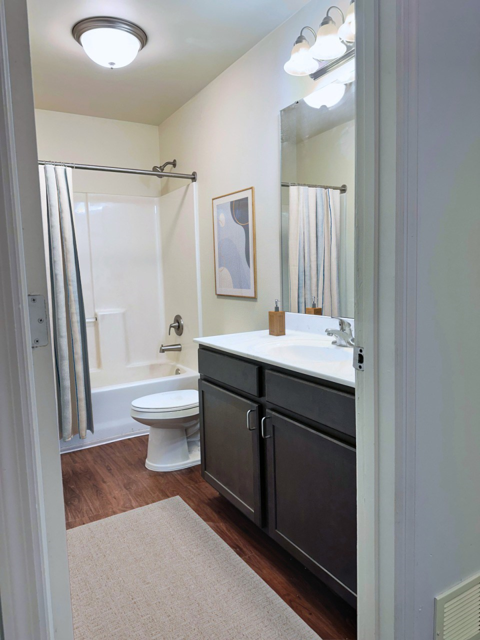 A bathroom with a toilet, sink, and mirror.