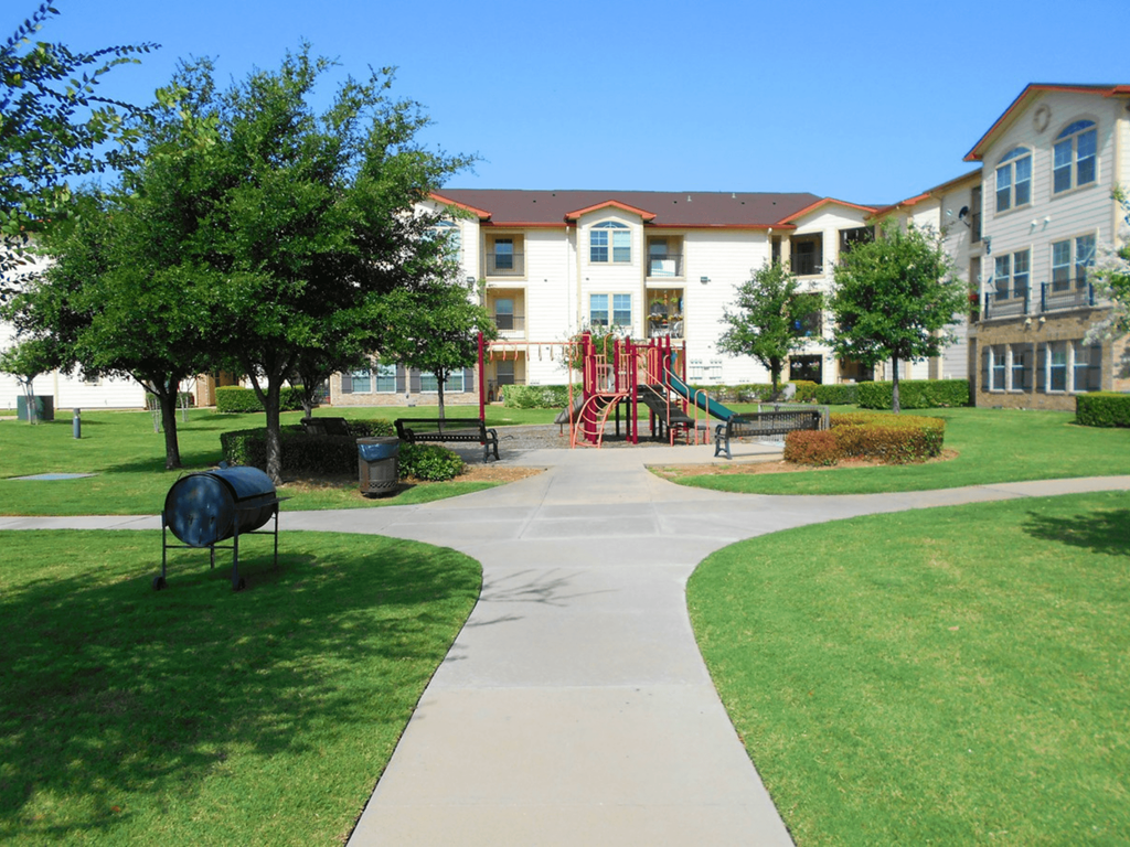 an exterior view of an apartment building with a playground
