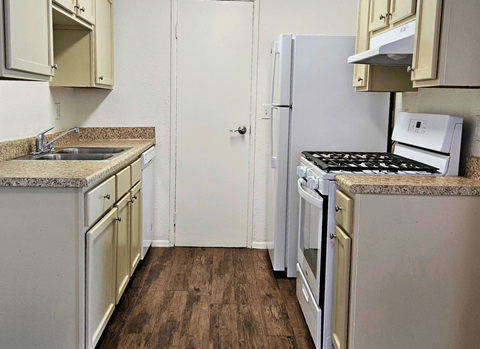 A kitchen with a white refrigerator, white oven, and a black stove top.
