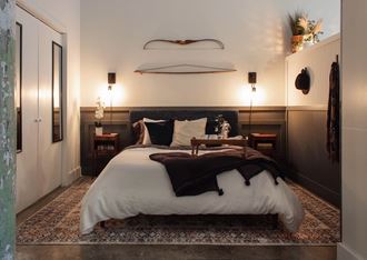 a bedroom with a bed and lamps on the wall