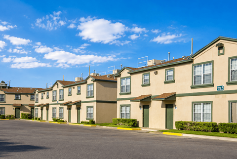 Apartment complex with a parking lot in front.