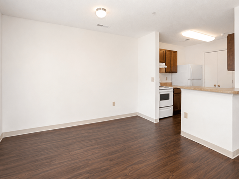 A kitchen with white cabinets and a wooden floor.