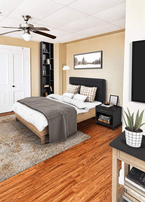 A bedroom with a bed, a ceiling fan, and a rug.