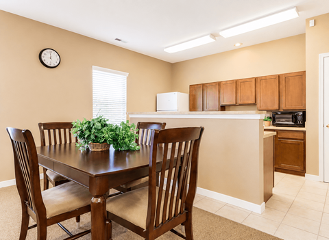 A dining room with a table and chairs.
