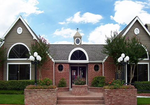 the front of a red brick house with a clock tower on the roof