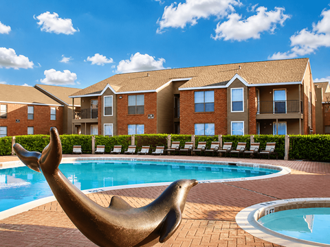 A seal statue is in front of a pool at a residential complex.