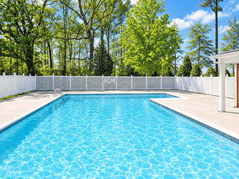A rectangular pool with a white fence around it.