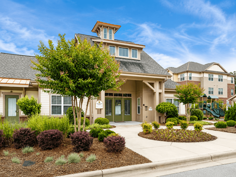 A large, well-maintained building with a landscaped front yard.