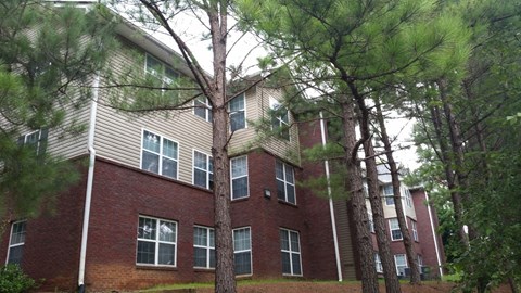 an apartment building with trees in front of it