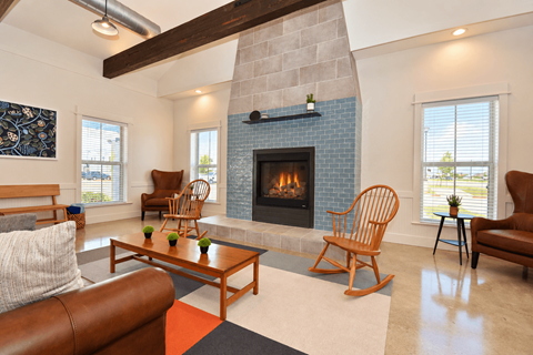 A clubhouse with a seating area with a fireplace and a couch.