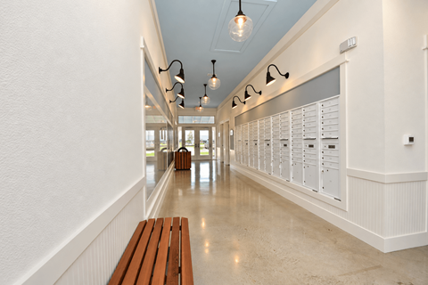 A long hallway with a bench and lights on the ceiling.