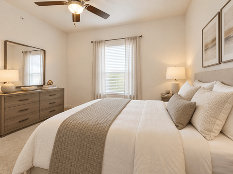 A bedroom with a large bed and a ceiling fan.