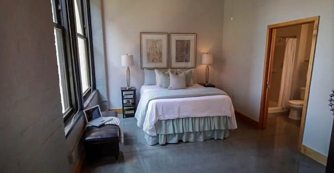 a bedroom with a bed and a large window