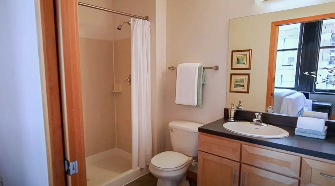 a bathroom with a sink toilet and shower and a mirror