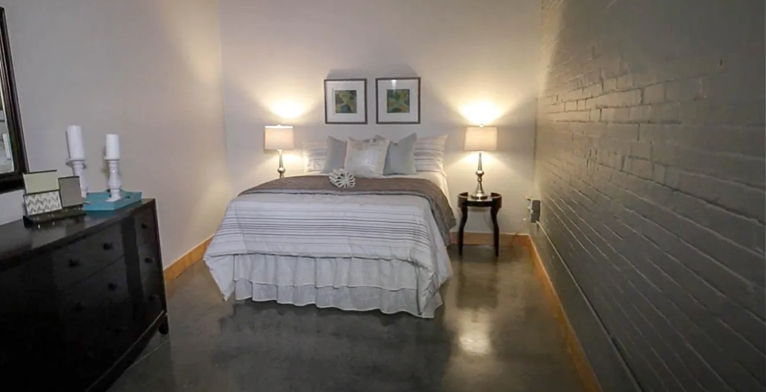 a bedroom with a bed and a brick wall