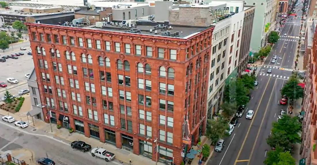 an aerial view of a tall brick building on a city street