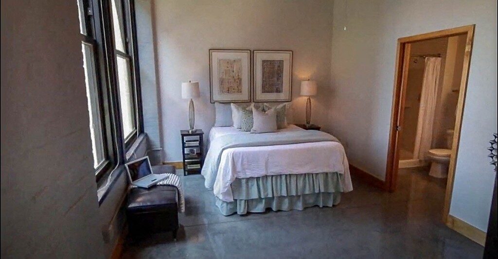 a bedroom with a bed and a large window