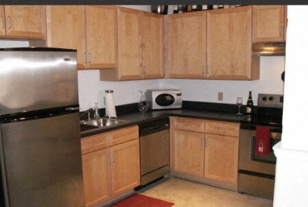 a kitchen with stainless steel appliances and wooden cabinets