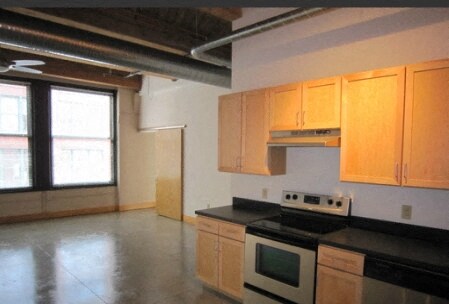 an empty kitchen with a stove and a window