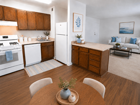A kitchen with white appliances and wooden cabinets.
